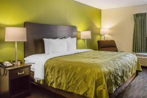 a hotel room with a large bed and a chair at Quality Inn in Culpeper