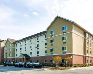 a large building with cars parked in a parking lot at Stafford Suites by IHG in Stafford
