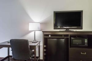 a room with a desk and a tv and a chair at Quality Inn in Culpeper