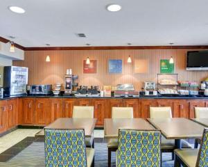 a restaurant with tables and chairs and a kitchen at Comfort Inn & Suites Airport Dulles-Gateway in Sterling