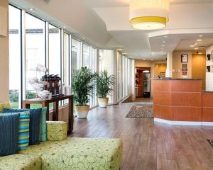 an office lobby with a couch and some windows at Comfort Suites Beachfront in Virginia Beach