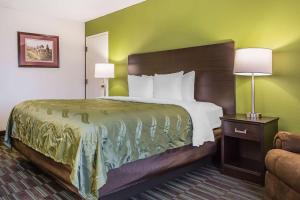 a hotel room with a large bed and a chair at Quality Inn in Culpeper