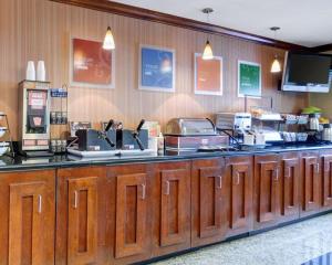
a kitchen with a large counter top and wooden cabinets at Comfort Inn & Suites Airport Dulles-Gateway in Sterling
