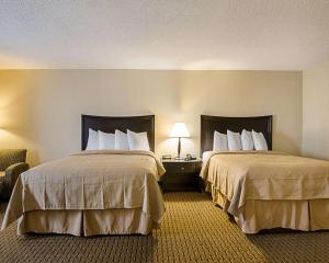 pokój hotelowy z dwoma łóżkami i krzesłem w obiekcie Quality Inn Troutville - Roanoke North w mieście Troutville +26 zdjęć