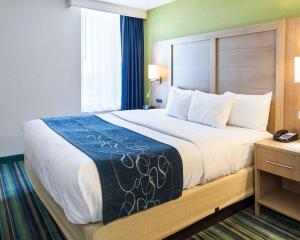 a bedroom with a large bed with a blue and white blanket at Comfort Suites Beachfront in Virginia Beach