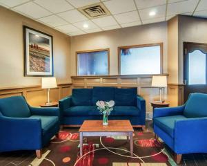 una sala de espera con sofás azules y una mesa con flores en Comfort Inn & Suites Raphine - Lexington near I-81 and I-64, en Raphine