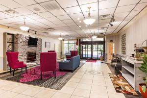 - un salon avec des chaises rouges et une cheminée dans l'établissement Clarion Hotel Williamsburg I-64, à Williamsburg