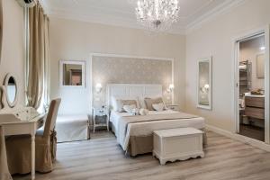 a white bedroom with a large bed and a desk at Charme & Chic Luxury in Rome