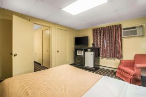 een hotelkamer met een bed en een stoel bij Rodeway Inn Rutland Killington in Rutland