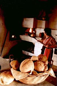 a woman standing in front of an oven with bread at Agriturismo La Pergola in Ischia