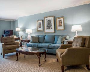 sala de estar con sofá azul y sillas en Comfort Inn & Suites Near Burke Mountain, en Saint Johnsbury