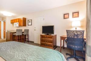 Habitación de hotel con cama, escritorio y TV. en Comfort Inn & Suites South Burlington en Burlington