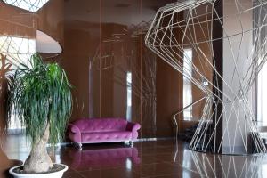 a living room with a pink couch and a plant at JR Hotels Bari Grande Albergo delle Nazioni in Bari