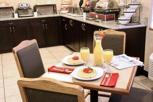 a table with two plates of food and glasses of orange juice at Comfort Inn Ellensburg in Ellensburg