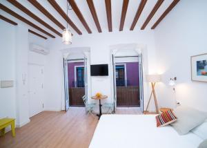 a bedroom with a bed and a table and two mirrors at Casa Hernando Colón in Seville