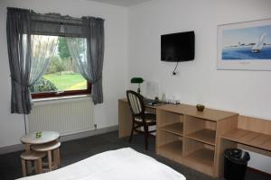 a hotel room with a bed and a desk and a window at Hotel Bov Kro in Padborg