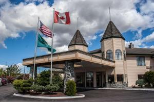 Quality Inn & Suites Fife Seattle في فايف: علمان يحلقان أمام المبنى