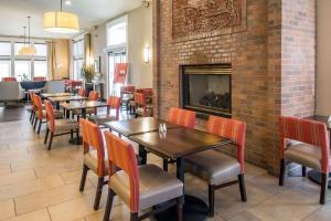 a restaurant with tables and chairs and a fireplace at Comfort Inn & Suites in Spokane Valley