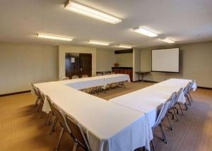 a conference room with tables and chairs and a white screen at Sleep Inn Pasco Tri -Cities in Pasco