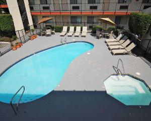 a large swimming pool with lounge chairs in a building at MorningGlory Inn & Suites in Bellingham