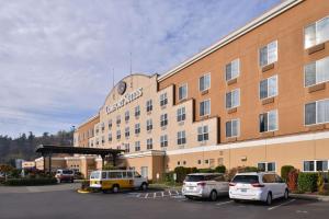 a large building with cars parked in a parking lot at Comfort Suites Airport Tukwila Seattle in Tukwila
