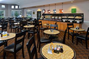 un restaurante con mesas, sillas y una barra en Comfort Suites Airport Tukwila Seattle, en Tukwila