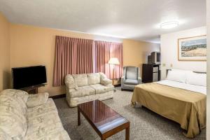 a hotel room with a bed a couch and a tv at Quality Inn in Moses Lake