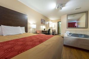 a hotel room with a bed and a bath tub at Econo Lodge in Buckley