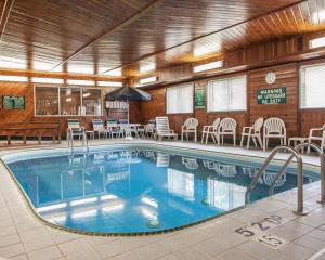 a pool in a hotel with tables and chairs at Quality Inn in Beloit