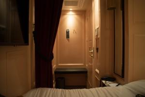 a room with a bed and a hallway with a door at Mimi's Hotel Soho in London