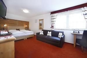 a bedroom with a bed and a couch in a room at Villa Seceda in Selva di Val Gardena