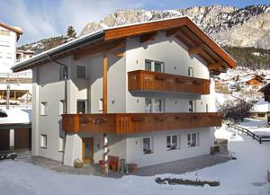a building with a balcony on it in the snow at Villa Seceda in Selva di Val Gardena