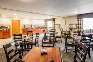 a restaurant with tables and chairs and a kitchen at Clarion Inn Renton-Seattle in Renton