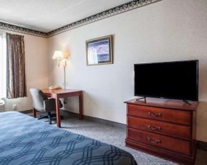 um quarto de hotel com uma cama e uma televisão de ecrã plano em Rodeway Inn & Suites Milwaukee Airport em Milwaukee