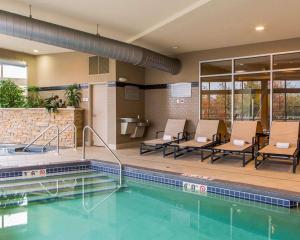 uma piscina num hotel com cadeiras e uma mesa em Cambria Hotel Appleton em Appleton