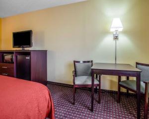 a hotel room with a bed and a table and chairs at Quality Inn Central Wisconsin Airport in Mosinee