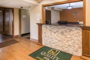a lobby with a bar in a hotel room at Quality Inn in Janesville
