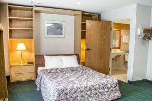 a hotel room with a bed and a bathroom at Rodeway Inn Abbotsford in Abbotsford