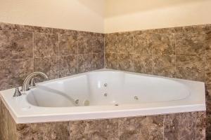 baño con bañera blanca grande y azulejos en Quality Inn & Suites Marinette, en Marinette