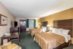 a hotel room with two beds and a desk at Quality Inn Wausau in Wausau