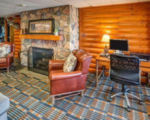 a living room with a stone fireplace and a desk at Quality Inn Ashland - Lake Superior in Ashland