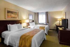 a hotel room with two beds and a television at Quality Inn Summersville in Summersville