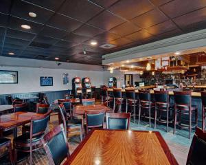 a restaurant with wooden tables and chairs and a bar at Quality Inn Beckley in Beckley