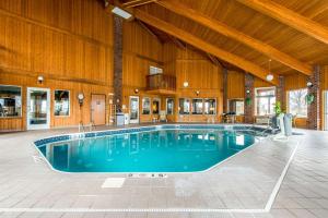 a large swimming pool in a building with a wooden ceiling at Comfort Inn in Weirton