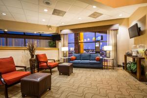 poczekalnia z niebieską kanapą i krzesłami w obiekcie Comfort Inn & Suites Madison - Airport w mieście Madison