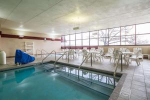 einen Pool mit Tischen und Stühlen in einem Zimmer in der Unterkunft Comfort Inn & Suites Madison - Airport in Madison