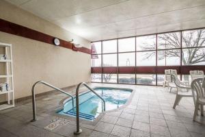 a pool in a room with a table and chairs at Comfort Inn & Suites Madison - Airport in Madison