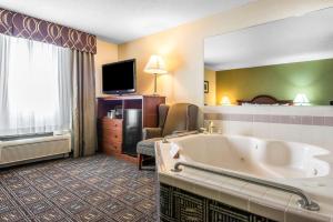 a hotel room with a bath tub and a television at Comfort Inn in Weirton