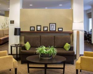 a lobby with a couch and a table and chairs at Sleep Inn & Suites Moundsville - Wheeling in Moundsville