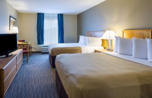 a hotel room with two beds and a flat screen tv at Quality Inn in Princeton
